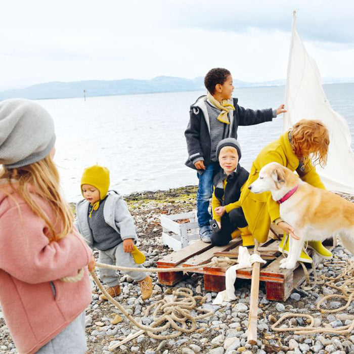 Kinder am See mit Hund am Floos bauen